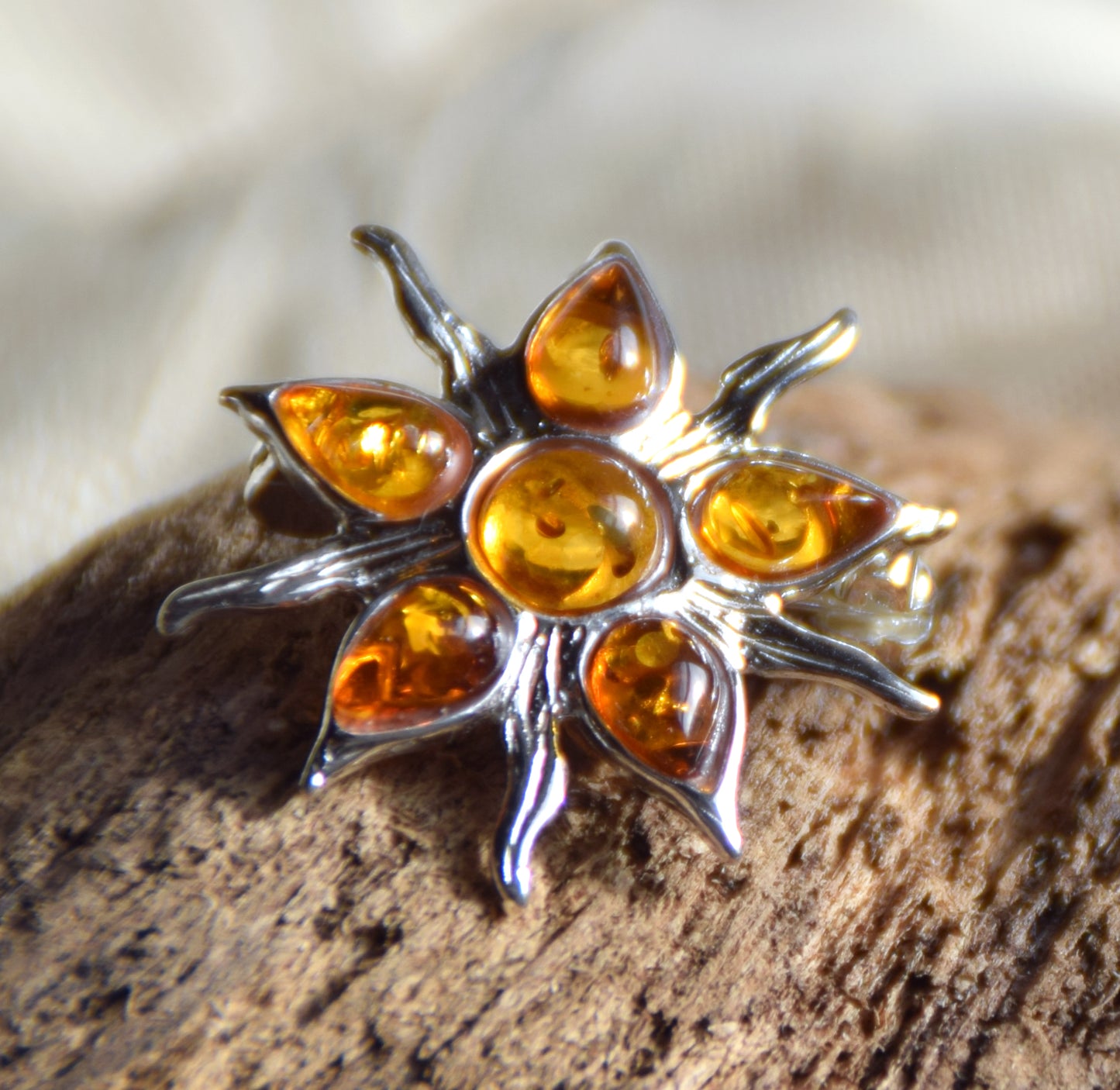 Spilla a forma di sole creata con mosaico di gemme di Ambra naturale color cognac e Argento 925, MJ Baltica, BBR059