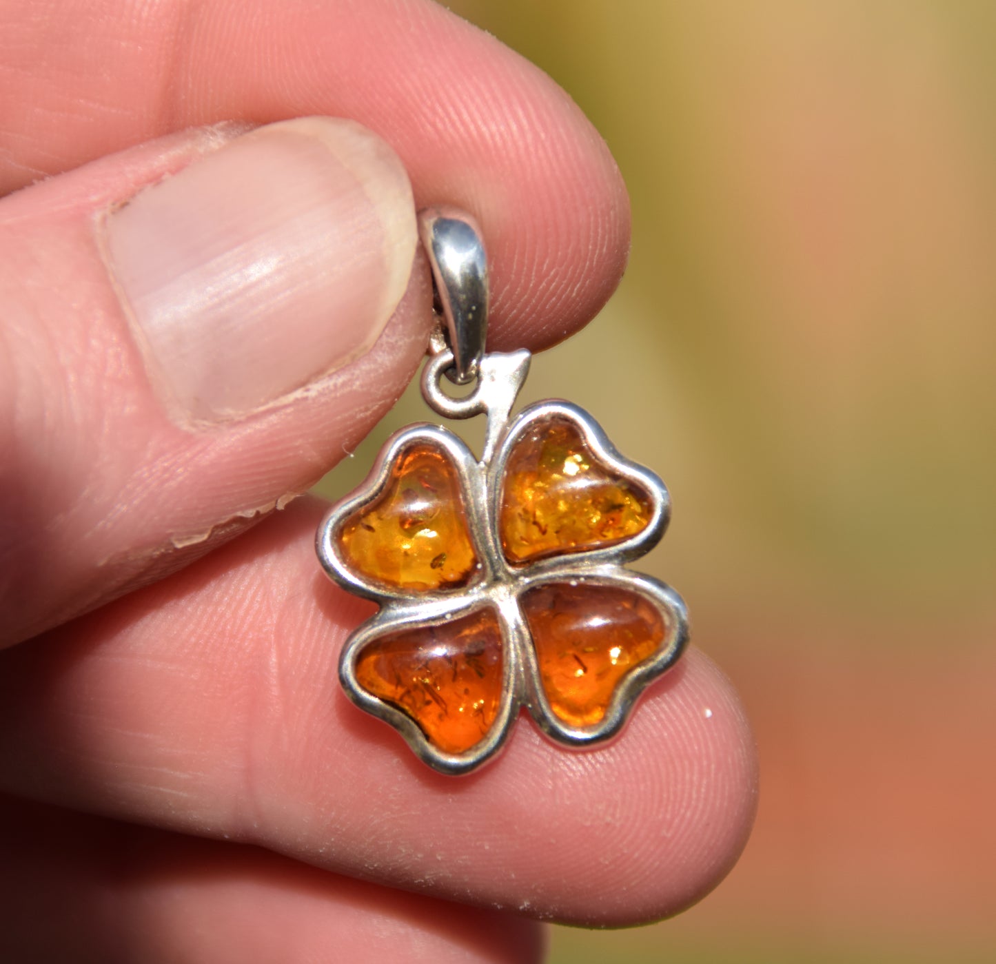 Bright pendant with a four-leaf clover of natural cognac-colored Amber leaves in Sterling Silver 925, MJ Baltica, BW313