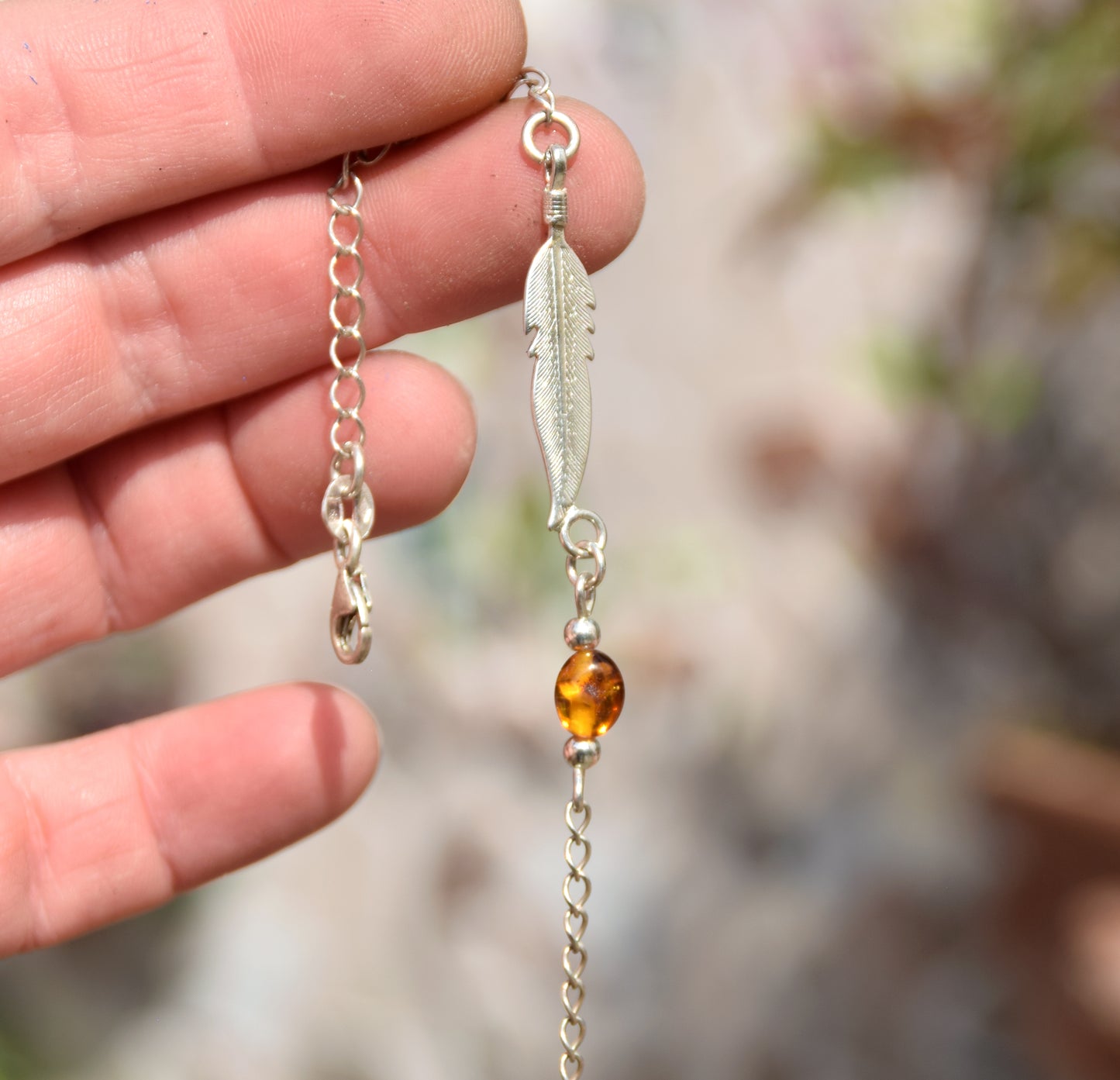 Delicato bracciale con luminosa piuma in Ambra naturale color cognac e Argento 925, MJ Baltica, BB005