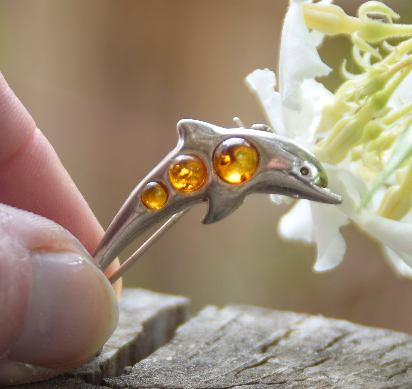 Delicate dolphin-shaped brooch crafted from natural cognac amber and 925 Sterling Silver, MJ Baltica, BBR013