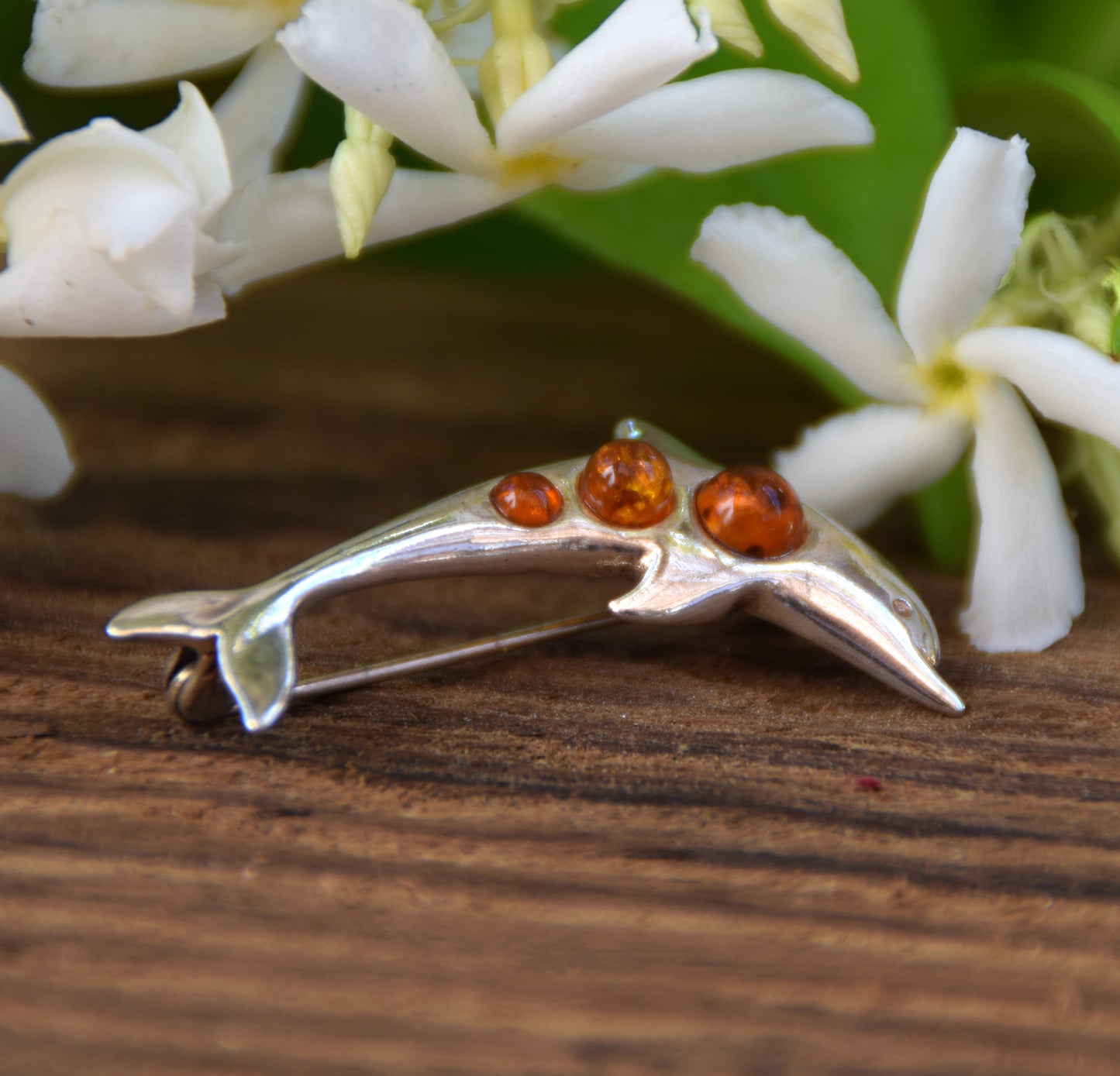 Delicate dolphin-shaped brooch crafted from natural cognac amber and 925 Sterling Silver, MJ Baltica, BBR013
