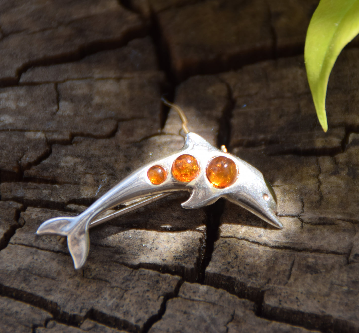 Delicate dolphin-shaped brooch crafted from natural cognac amber and 925 Sterling Silver, MJ Baltica, BBR013