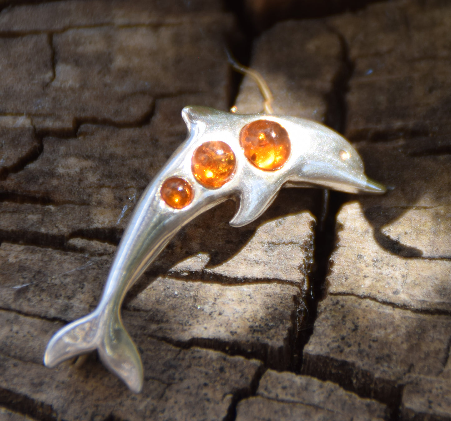 Delicate dolphin-shaped brooch crafted from natural cognac amber and 925 Sterling Silver, MJ Baltica, BBR013