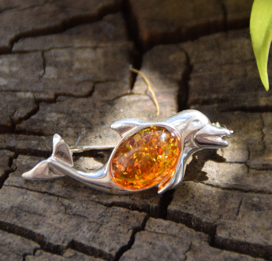 Luminous dolphin brooch in marine style, crafted from natural cognac amber and 925 sterling silver, MJ Baltica, BBR014