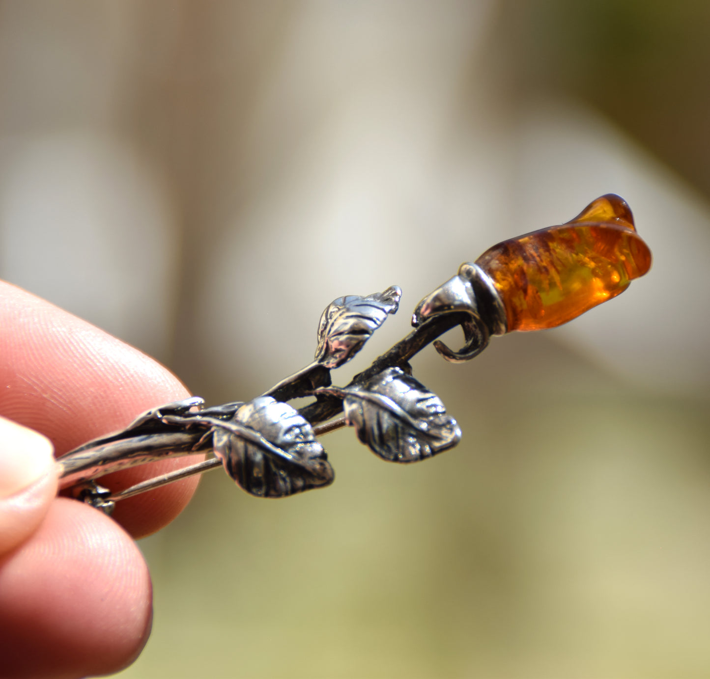 Elegant rose-shaped brooch crafted from natural cognac amber and 925 sterling silver, MJ Baltica, BBR030