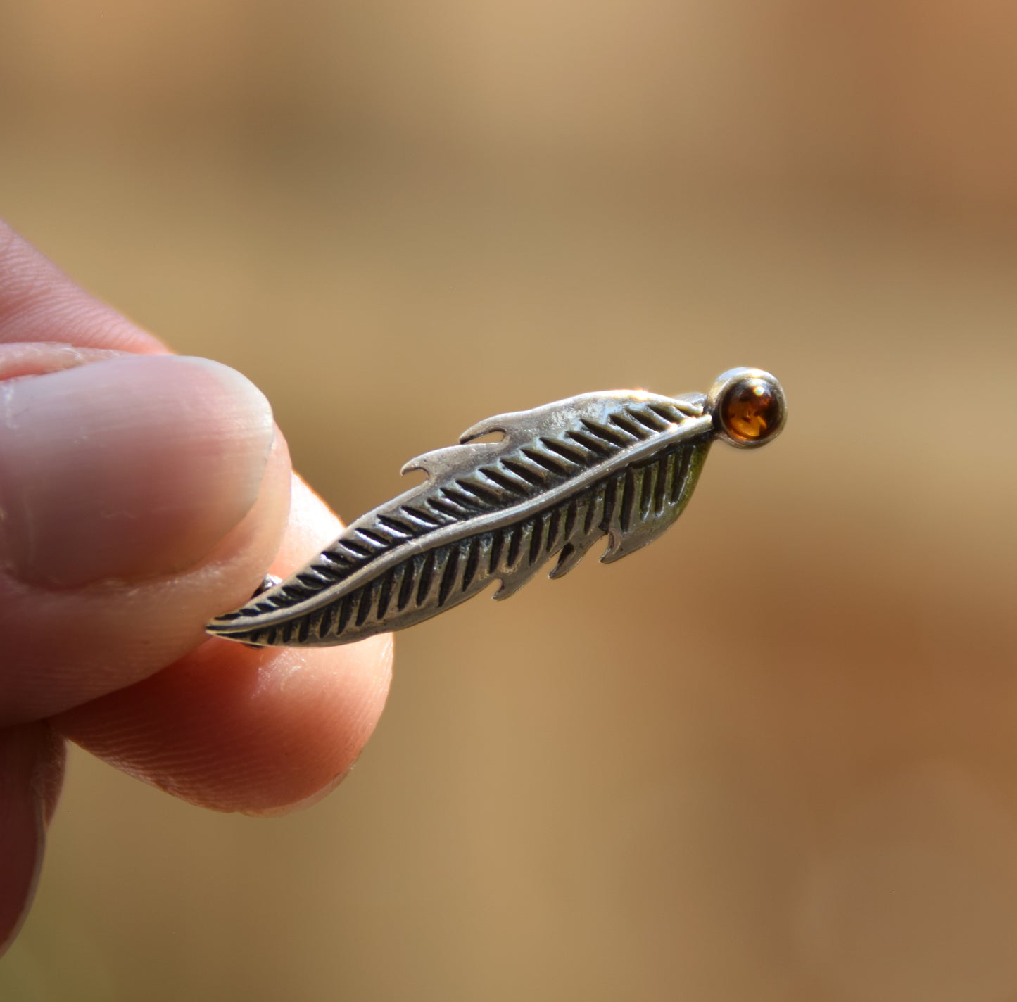 Delicate feather brooch made with natural cognac-colored amber and 925 silver, MJ Baltica, BBR050