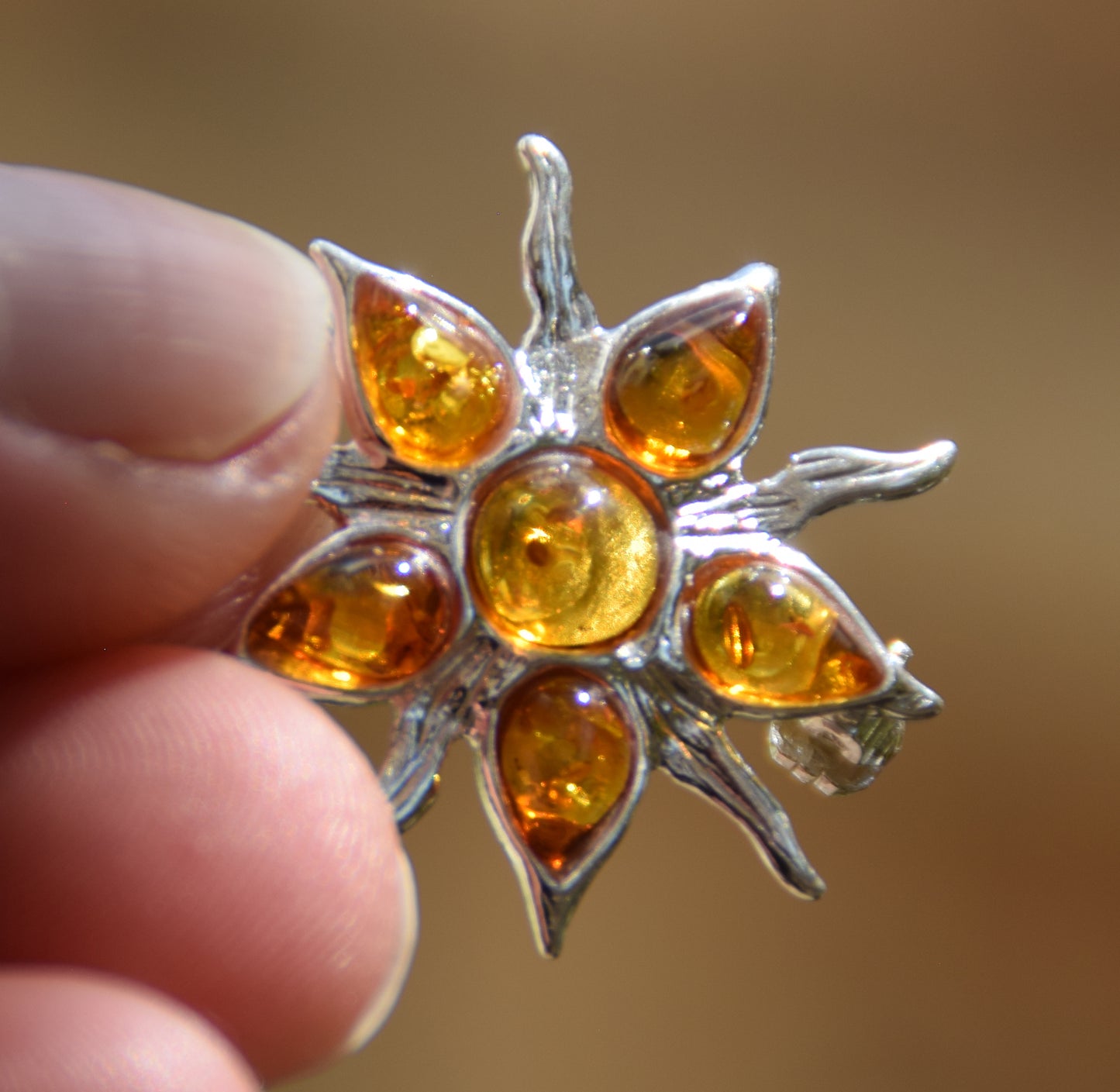 Spilla a forma di sole creata con mosaico di gemme di Ambra naturale color cognac e Argento 925, MJ Baltica, BBR059