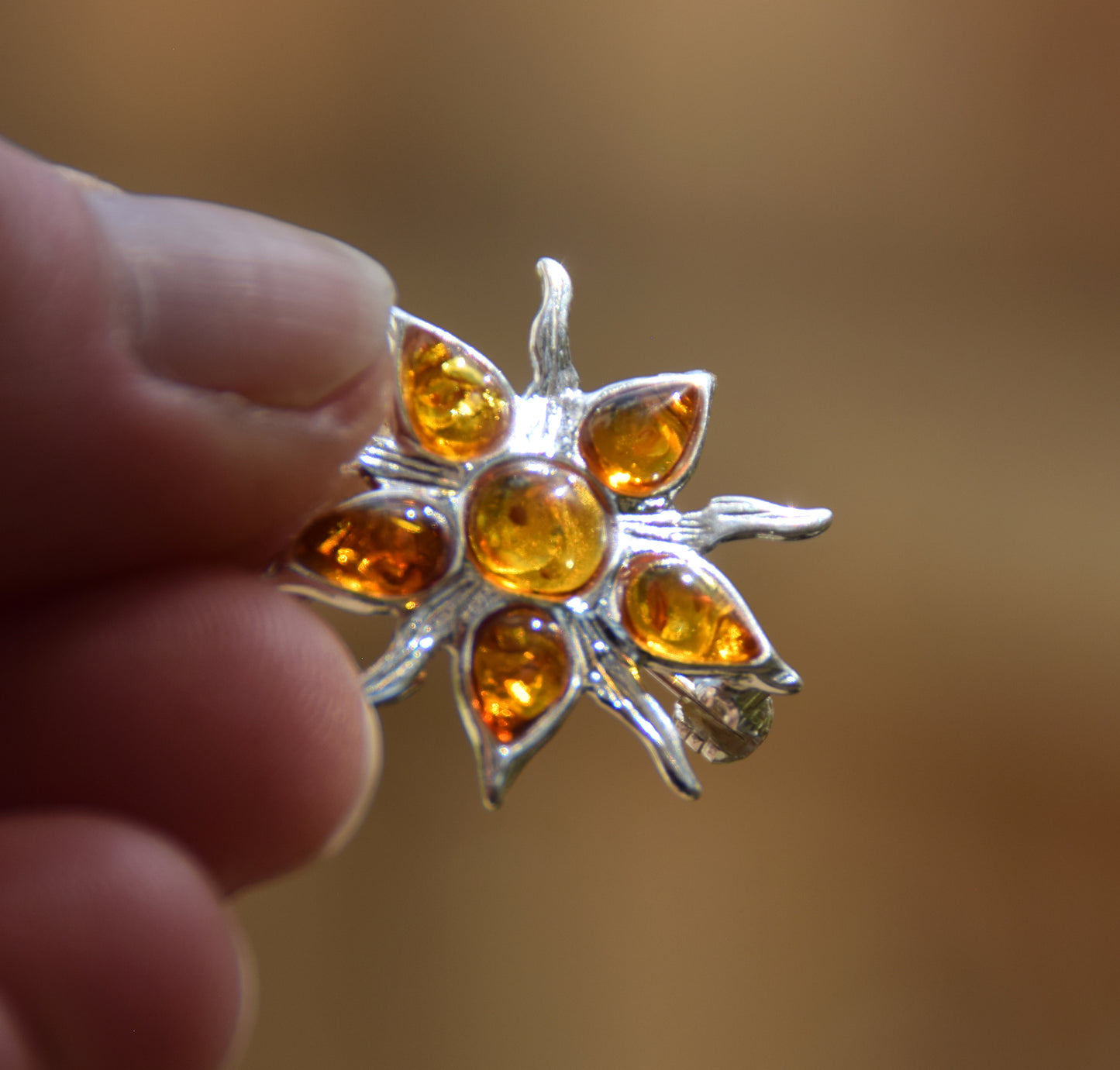 Spilla a forma di sole creata con mosaico di gemme di Ambra naturale color cognac e Argento 925, MJ Baltica, BBR059