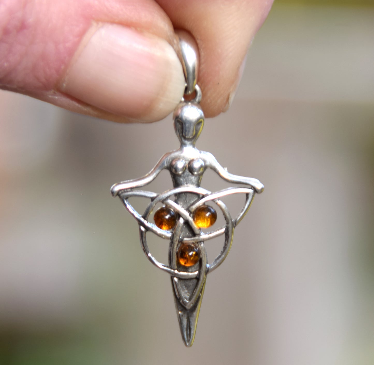 Celtic fairy pendant holding a triskele adorned with natural cognac amber, MJ Baltica, BW050