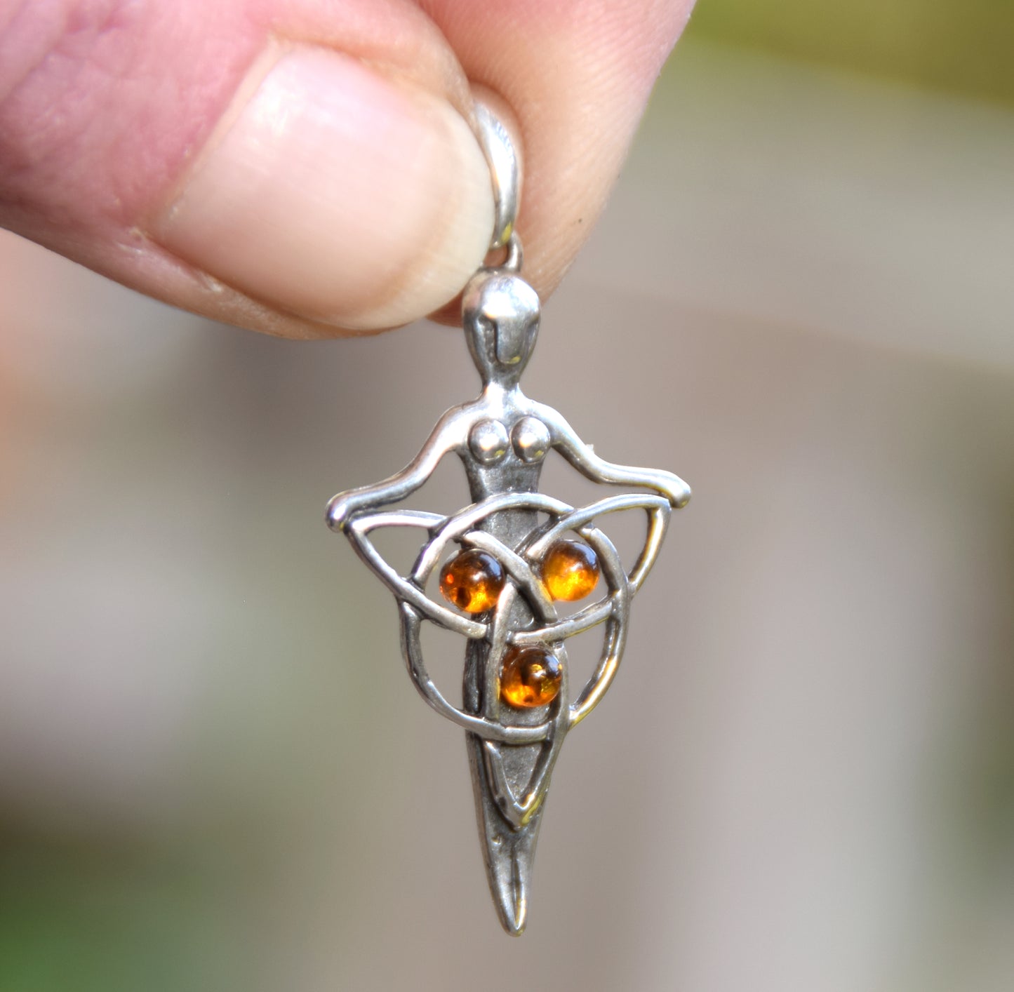 Celtic fairy pendant holding a triskele adorned with natural cognac amber, MJ Baltica, BW050