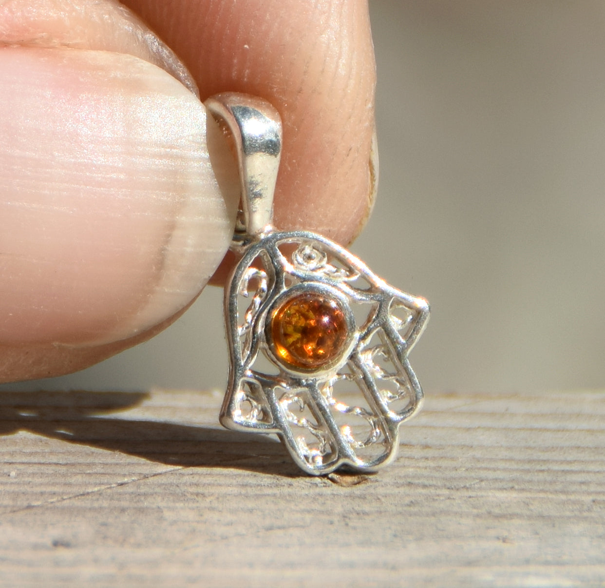 Delicato ciondolo con mano di Fatima in Ambra naturale color cognac e Argento 925, MJ Baltica, BW139