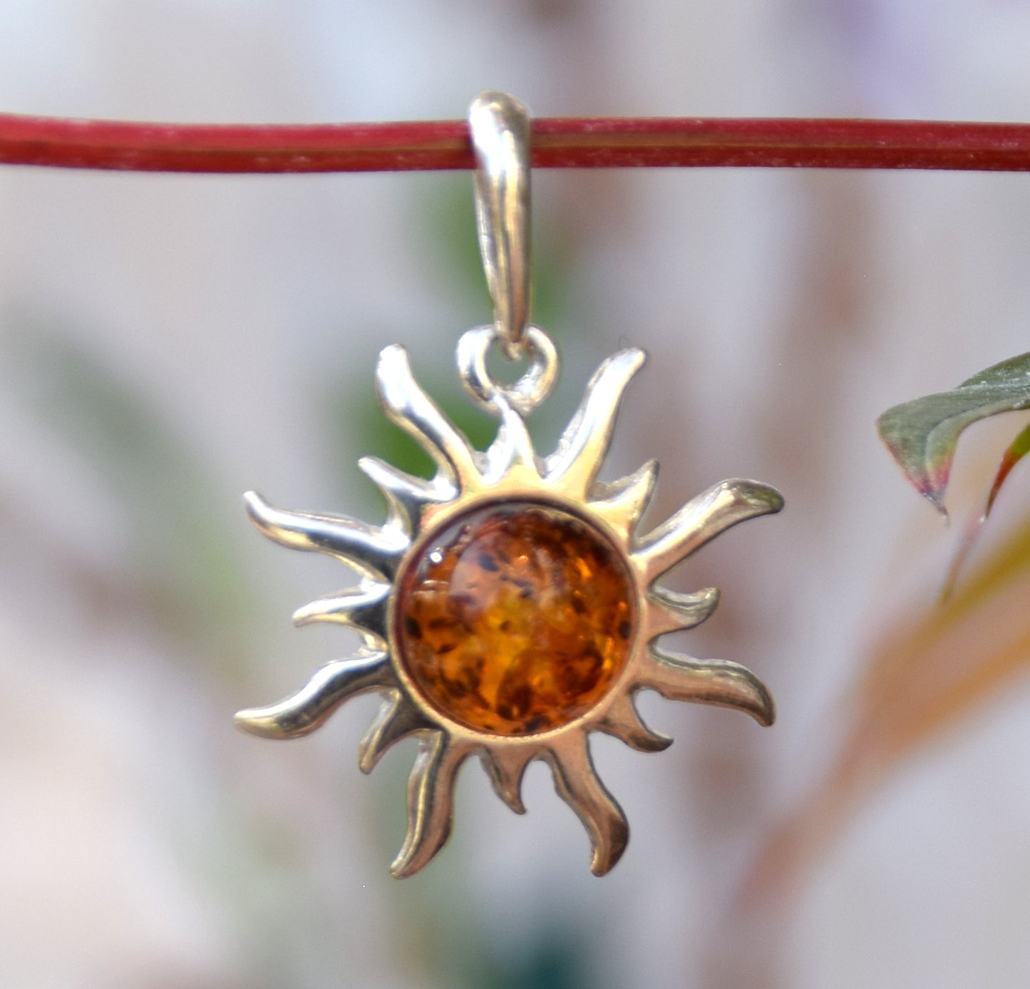 Bright sun-shaped pendant in natural cognac amber and 925 sterling silver, MJ Baltica, BW167