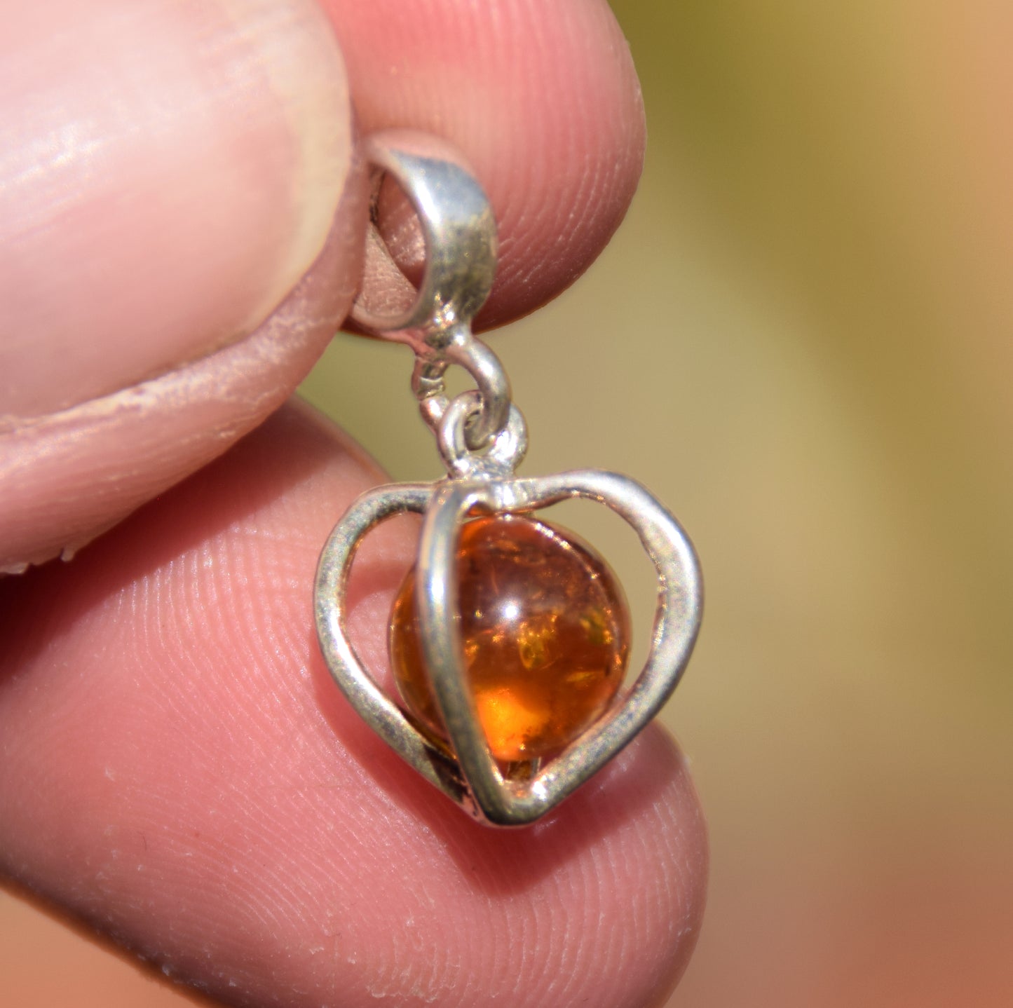 Delicate pendant with a cage-shaped heart in cognac-colored natural Amber and 925 Silver, MJ Baltica, BW318