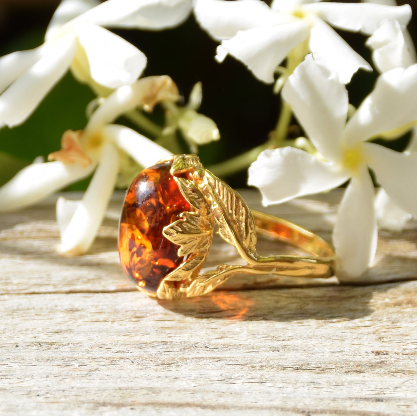 Vintage-style oval ring with floral decoration crafted from cognac-colored Natural Amber and 14k Gold-plated Silver, MJ Baltica, BZP025